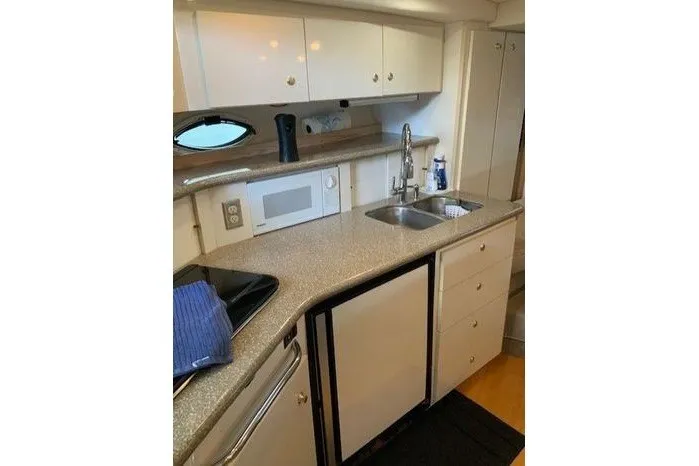 Slide: The Image of 2000 Maxum 3200 SCR yacht kitchen with sink, microwave, and compact fridge. - 13