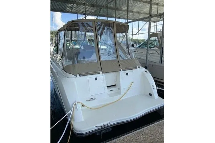 Slide: The Image of 2000 Maxum 3200 SCR boat docked, featuring a covered cockpit and sleek design. - 4