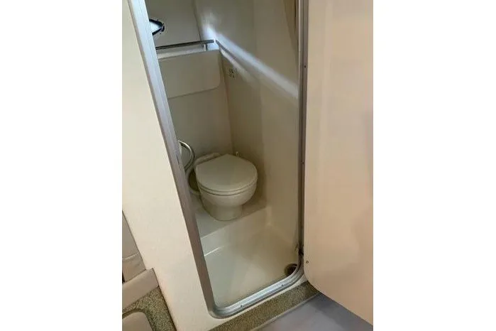 Slide: The Image of Compact bathroom in 2000 Maxum 3200 SCR boat, featuring a toilet and shower area. - 14