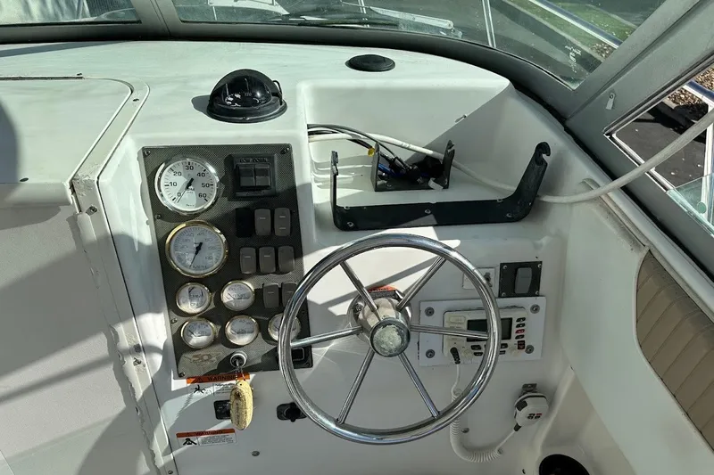 Slide: The Image of 2005 Seaswirl Striper 2301 Walkaround I/O dashboard with gauges, steering wheel, and controls. - 21
