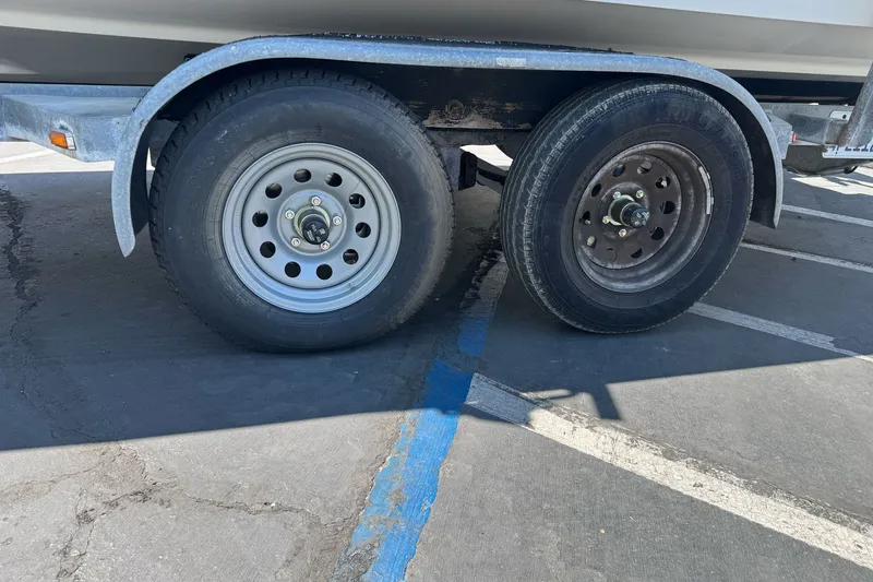 Slide: The Image of Trailer wheels of a 2005 Seaswirl Striper 2301 Walkaround I/O boat in a parking lot. - 3