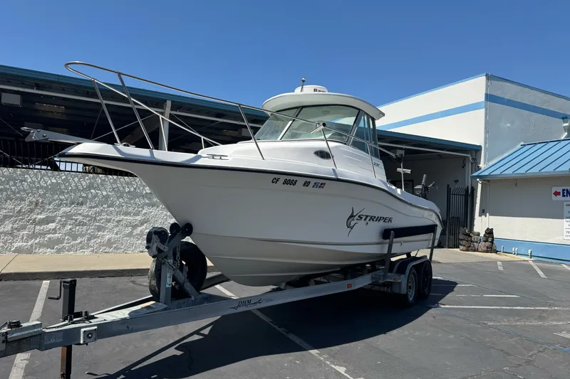 Slide: The Image of 2005 Seaswirl Striper 2301 Walkaround I/O boat on trailer, parked outdoors. - 2