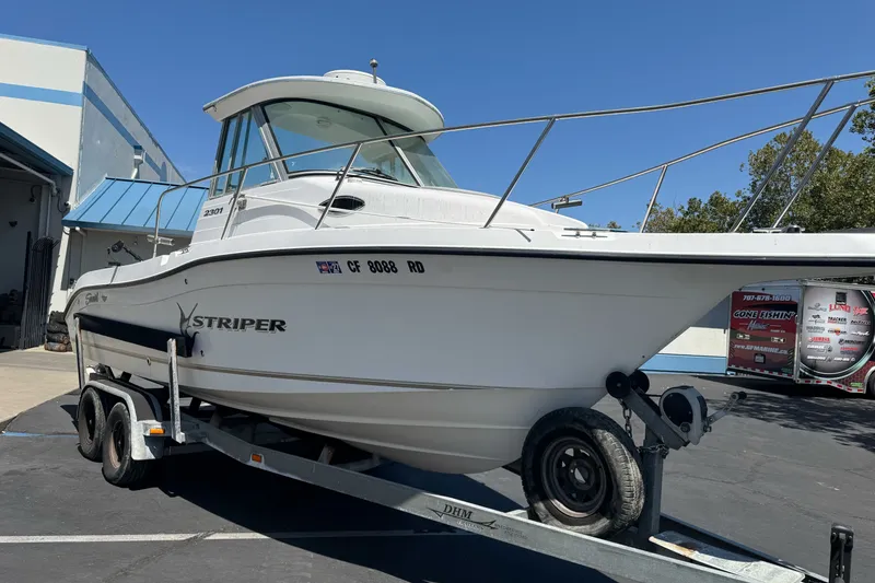 Slide: The Image of 2005 Seaswirl Striper 2301 Walkaround I/O boat on trailer, parked outdoors. - 5