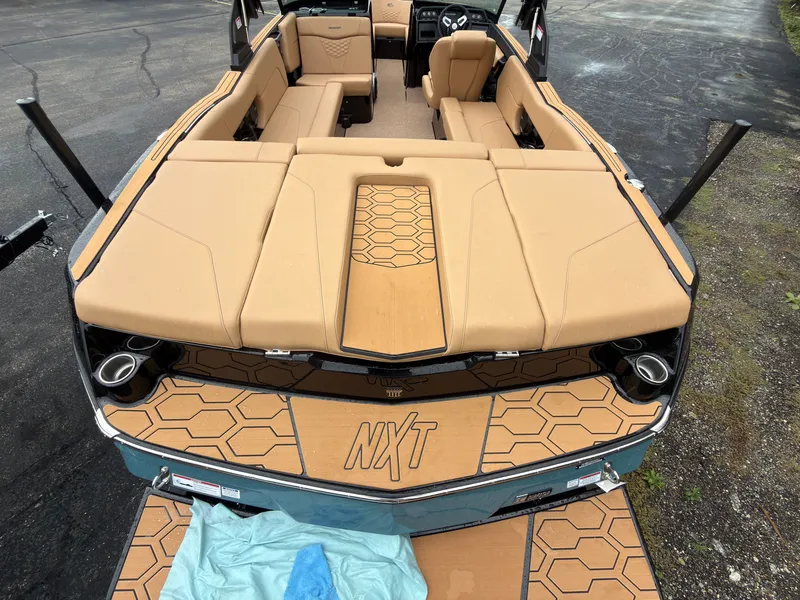 Slide: The Image of The image shows the stern of a MasterCraft NXT23 boat with beige upholstery and hexagonal patterns. - 8