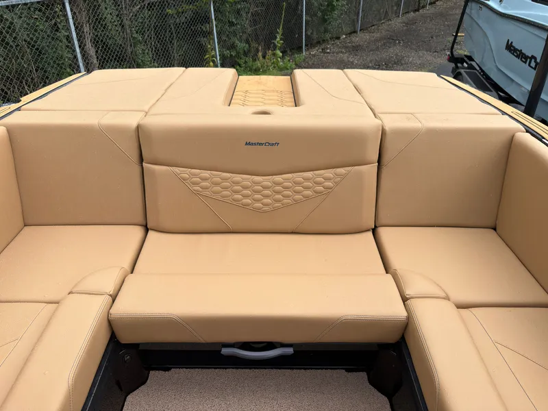 Slide: The Image of The image shows the beige upholstery in the rear seating area of a MasterCraft NXT23 boat. - 18