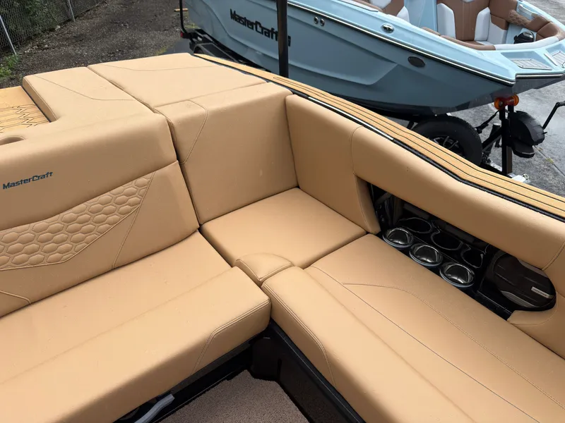 Slide: The Image of The image shows the beige upholstery of a MasterCraft NXT23 boat with cup holders. - 19