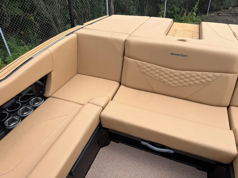 Slide: The Image of The image shows the beige upholstery in the rear seating area of a MasterCraft NXT23 boat. - 17