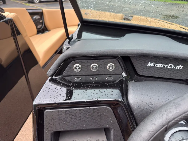 Slide: The Image of The image shows the dashboard of a MasterCraft NXT23 boat with raindrops on it. - 32