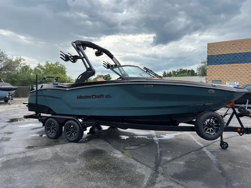 Slide: The Image of A 2027 MasterCraft NXT23 boat on a trailer. It features a modern design and a tower. - 5