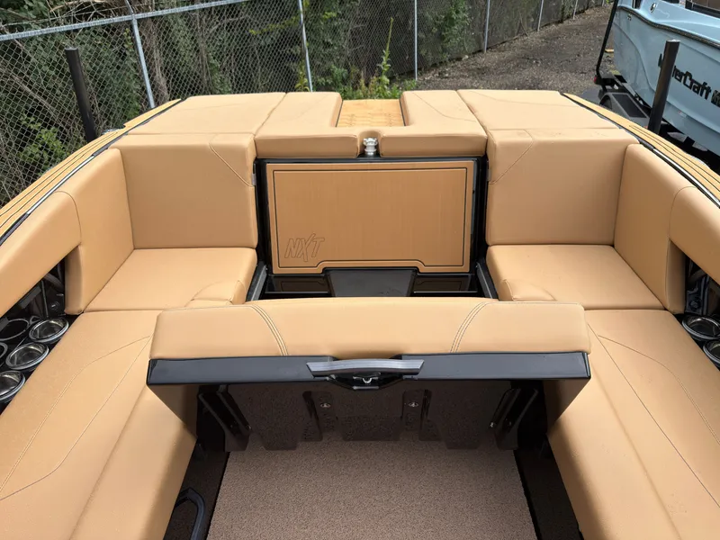 Slide: The Image of The image shows the beige upholstered stern of a 2027 MasterCraft NXT23 boat. - 25