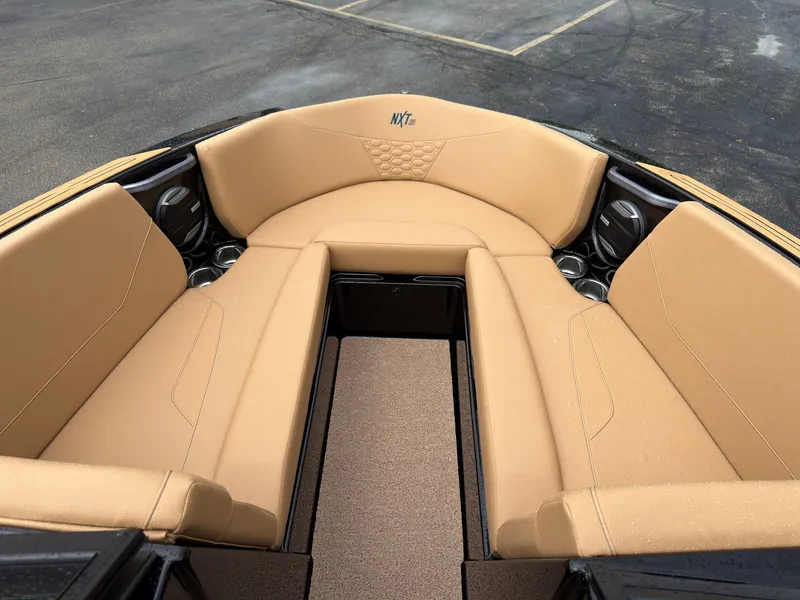 Slide: The Image of The image shows the bow area of a MasterCraft NXT23 boat with beige upholstery and cup holders. - 47