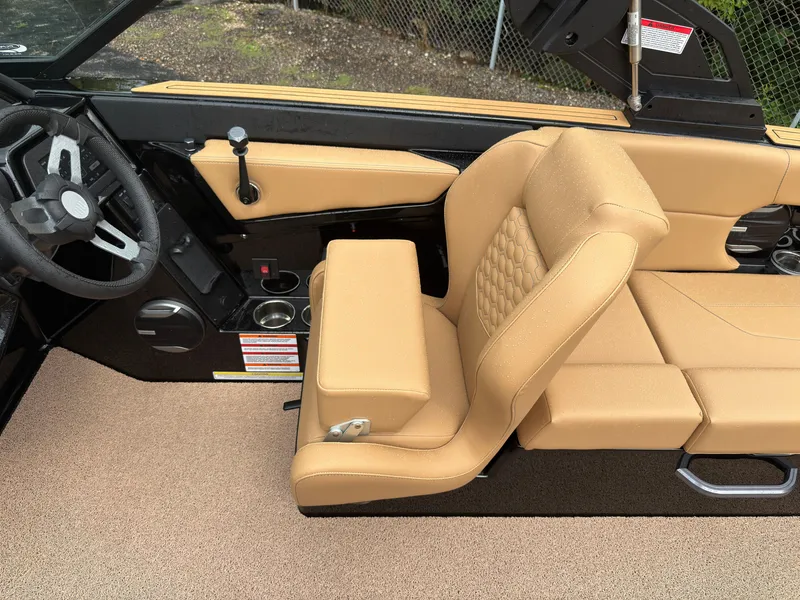Slide: The Image of The image shows the interior of a MasterCraft NXT23 boat with beige upholstery and a black dashboard. - 29