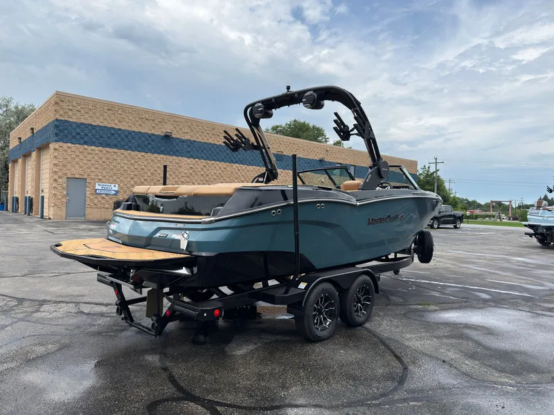 Slide: The Image of A modern 2027 MasterCraft NXT23 sits on a trailer in a parking lot. - 6