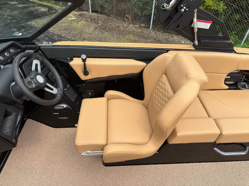 Slide: The Image of The image shows the interior of a MasterCraft NXT23 boat with beige leather seats and a black dashboard. - 28