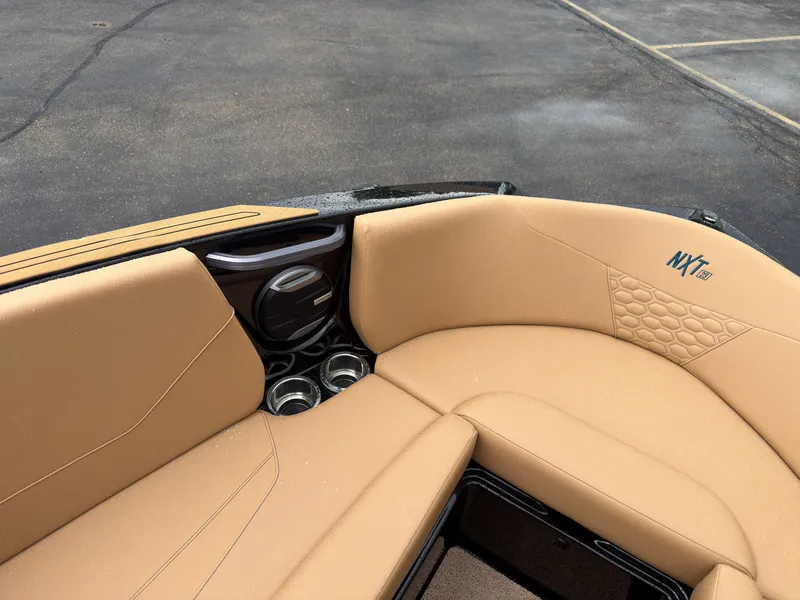 Slide: The Image of The image shows the bow area of a MasterCraft NXT23 boat with beige upholstery and cup holders. - 49