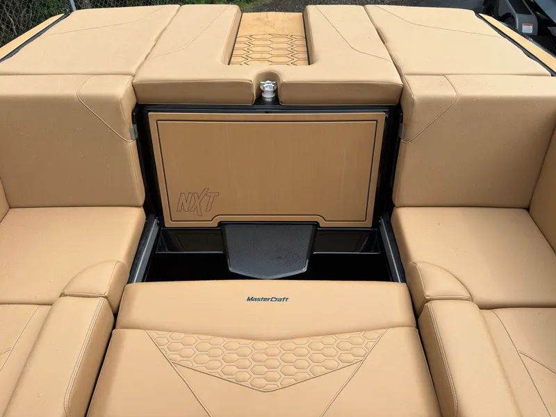 Slide: The Image of The image shows the beige upholstery layout of a 2027 MasterCraft NXT23 boat. - 26