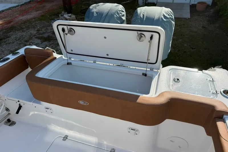 Slide: The Image of 2024 Sea Hunt Gamefish 30CB boat with open storage compartment and cushioned seating. - 17
