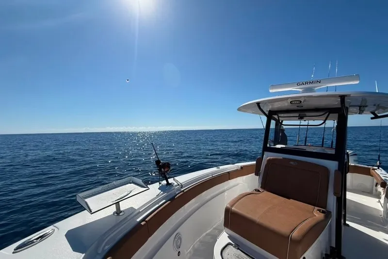 Slide: The Image of 2024 Sea Hunt Gamefish 30CB boat on open ocean under clear blue sky. - 14