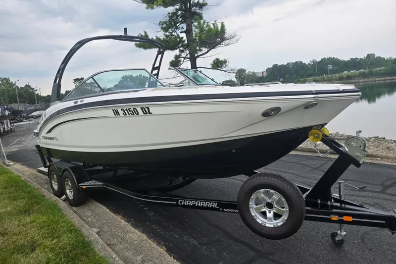 Slide: The Image of 2017 Chaparral 246 SSi boat on trailer, parked near a calm waterfront. - 8