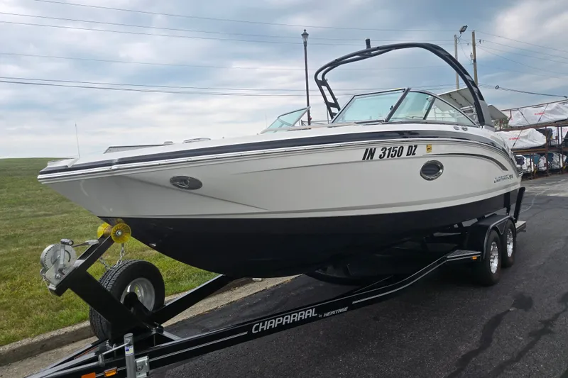 Slide: The Image of 2017 Chaparral 246 SSi boat on trailer, parked outdoors under cloudy sky. - 5