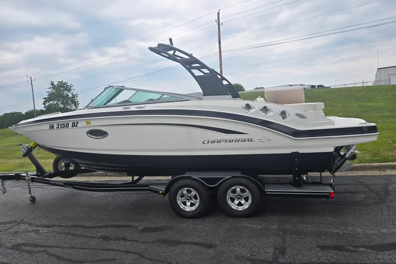 Slide: The Image of 2017 Chaparral 246 SSi boat on trailer, parked on a road with grassy background. - 4