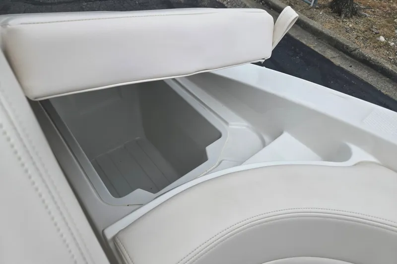 Slide: The Image of 2017 Chaparral 246 SSi boat interior storage compartment with white cushioned seating. - 26