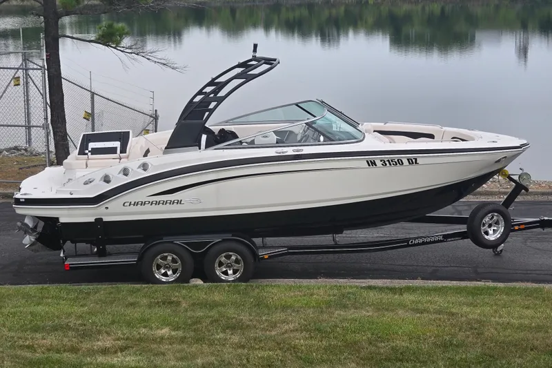 The Image of 2017 Chaparral 246 SSi boat on trailer by a serene lake. - 0