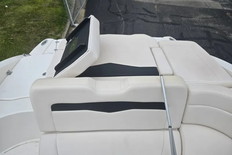 Slide: The Image of 2017 Chaparral 246 SSi boat with white and black seating, parked on pavement. - 24