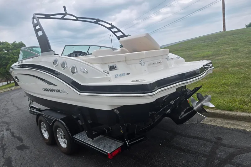 Slide: The Image of 2017 Chaparral 246 SSi boat on trailer, rear view, parked on asphalt near grass. - 3