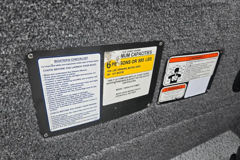 Slide: The Image of 2019 Tracker Targa V-18 Combo safety and capacity labels on boat interior. - 17