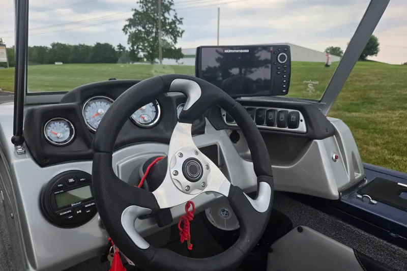 Slide: The Image of 2019 Tracker Targa V-18 Combo boat dashboard with steering wheel and navigation system. - 16