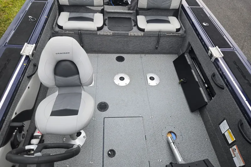 Slide: The Image of 2019 Tracker Targa V-18 Combo boat interior with gray seating and steering wheel. - 23