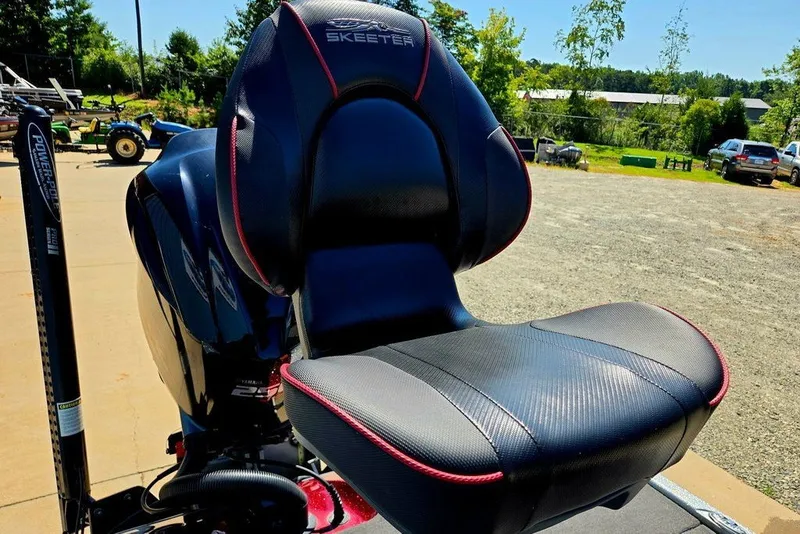 Slide: The Image of 2026 Skeeter ZXR21 boat seat with sleek black and red design in outdoor setting. - 37