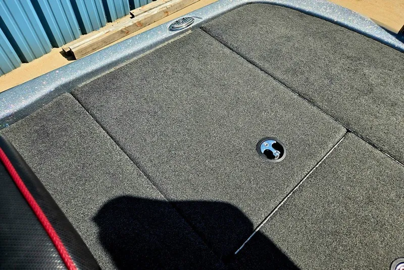 Slide: The Image of Carpeted deck of 2026 Skeeter ZXR21 boat with storage hatch and metal handle. - 27
