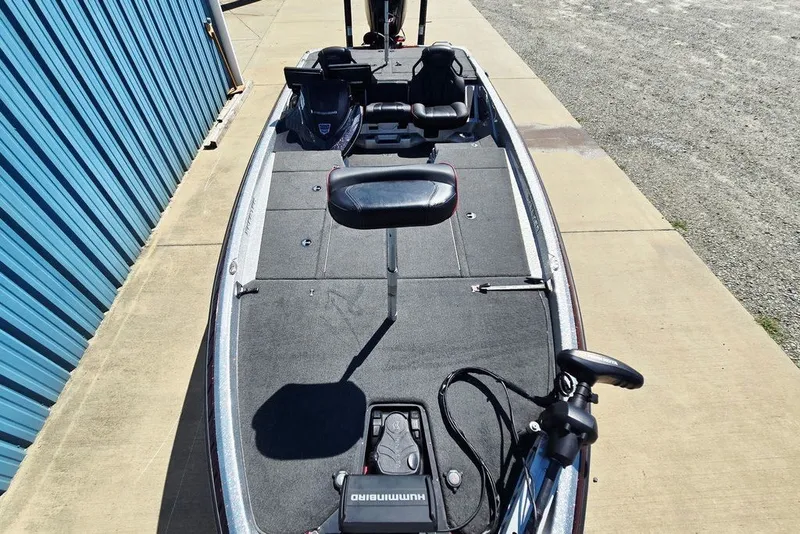 Slide: The Image of 2026 Skeeter ZXR21 fishing boat with seating and equipment, parked on concrete near blue building. - 6