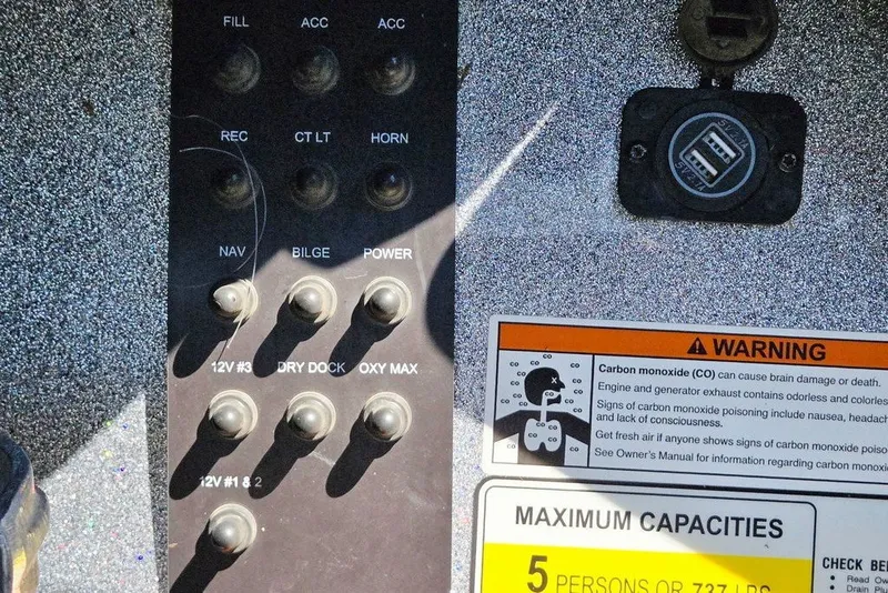 Slide: The Image of Control panel of a 2026 Skeeter ZXR21 boat with warning labels and switches. - 29