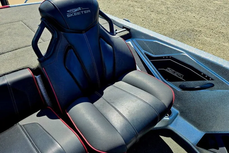 Slide: The Image of 2026 Skeeter ZXR21 boat seat with sleek black design and red accents. - 18