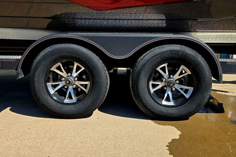 Slide: The Image of 2026 Skeeter ZXR21 trailer wheels on concrete, showcasing dual black tires and shiny rims. - 3