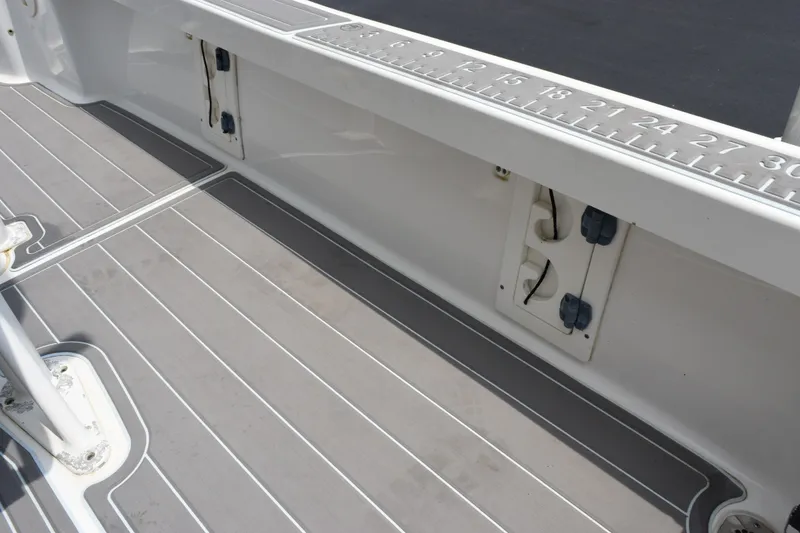Slide: The Image of 2016 Sea Hunt BX22BR boat deck with ruler and storage compartments. - 22