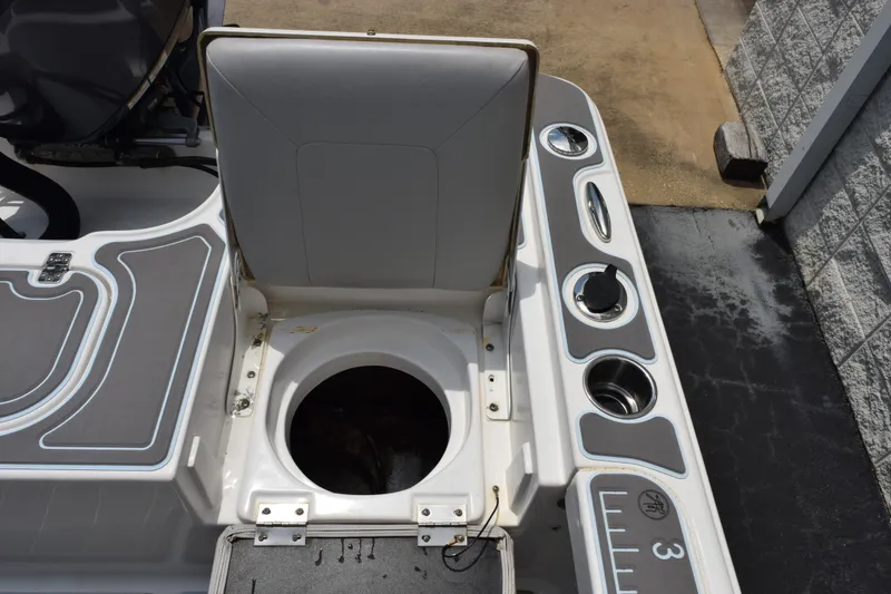 Slide: The Image of 2016 Sea Hunt BX22BR boat with open storage compartment and cup holders on deck. - 21