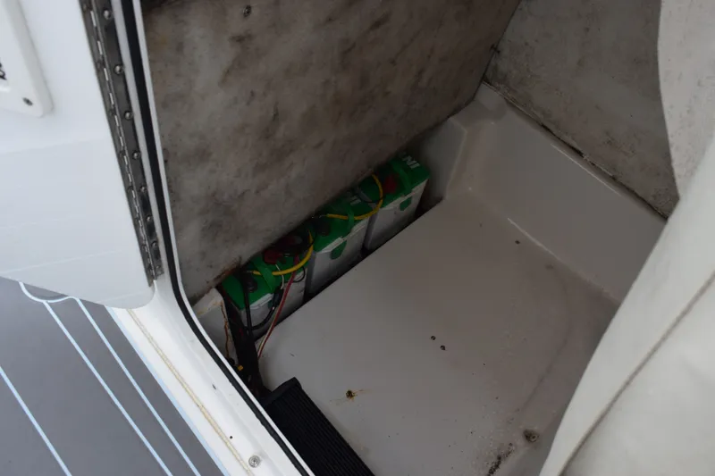 Slide: The Image of 2016 Sea Hunt BX22BR boat battery compartment with visible wiring and batteries. - 14