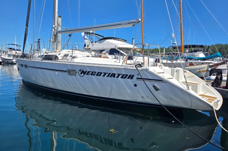 The Image of 1997 Jeanneau 51 sailboat "Negotiator" docked in a marina under clear blue skies. - 1