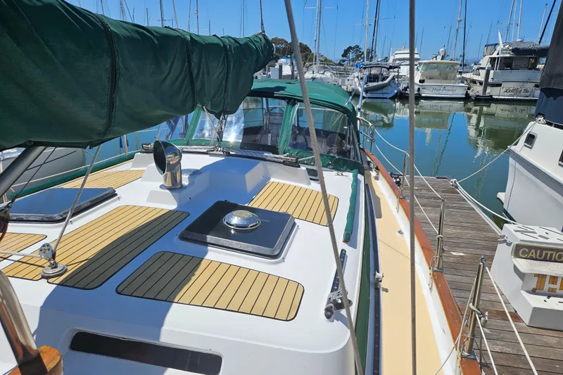 Slide: The Image of 1988 Hans Christian Christina sailboat docked in marina, featuring teak deck and green canopy. - 37
