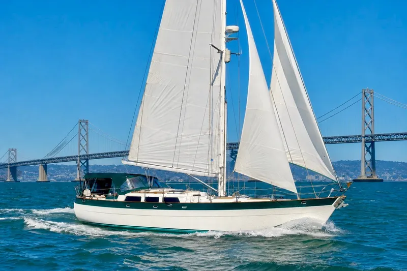 The Image of Sailing yacht Hans Christian Christina 1988 cruising near a bridge on a sunny day. - 0