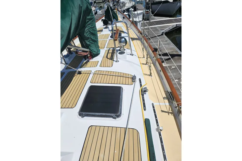 Slide: The Image of 1988 Hans Christian Christina sailboat deck with teak accents and marina view. - 40
