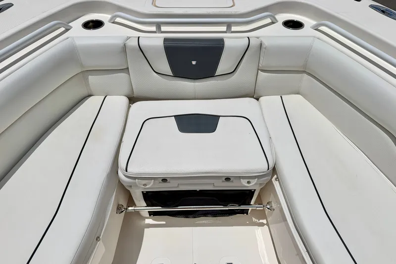 Slide: The Image of 2018 Wellcraft 302 Fisherman boat interior with white cushioned seating and storage compartment. - 12