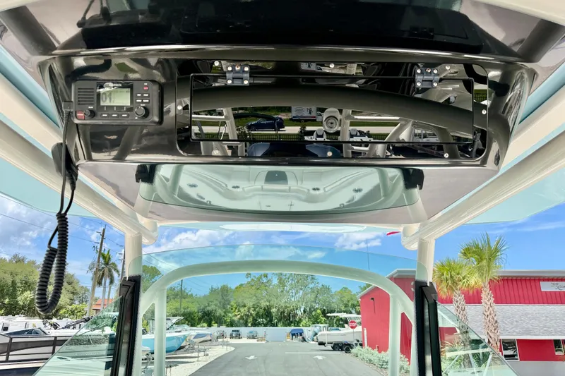 Slide: The Image of 2018 Wellcraft 302 Fisherman boat console with radio, clear sky, and palm trees. - 27