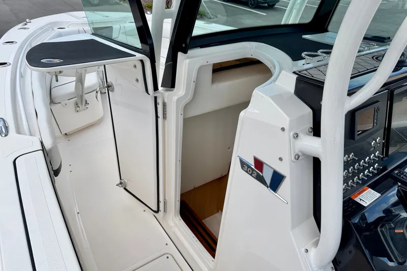 Slide: The Image of 2018 Wellcraft 302 Fisherman boat interior with open cabin door and control panel. - 32