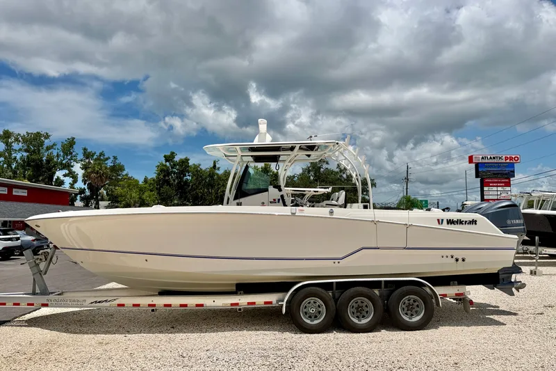 The Image of 2018 Wellcraft 302 Fisherman boat on trailer under cloudy sky. - 0
