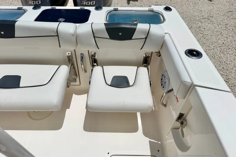 Slide: The Image of 2018 Wellcraft 302 Fisherman boat interior with white cushioned seating and dual outboard engines. - 36